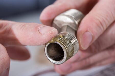 Plumber putting sealing paste on a thread, closeup