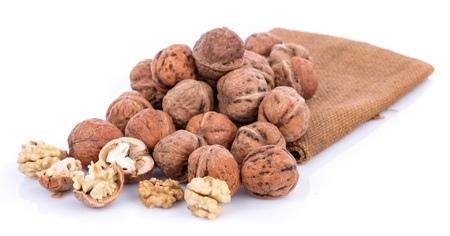 Fresh walnuts on burlap, isolated on whiteの写真素材