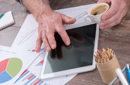 Businessperson analyzing financial charts with tablet computerの写真素材