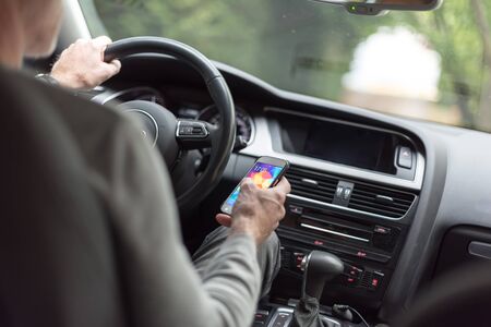 Man driving using smartphoneの写真素材
