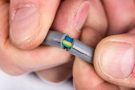 Hand removing the insulation of a power cable