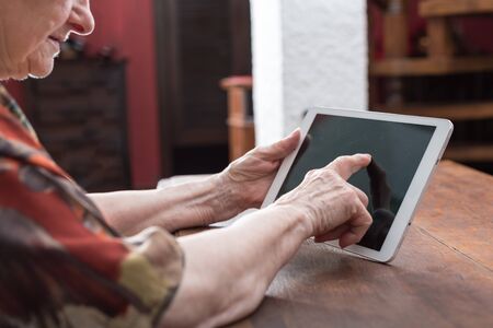 Old woman using tablet at homeの写真素材