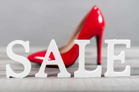 Sale sign with red high heel shoe on grey backgroundの写真素材