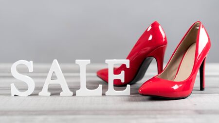 Sale sign with red high heels shoes on grey backgroundの写真素材