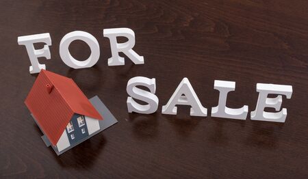 For sale sign with a house on wooden tableの写真素材