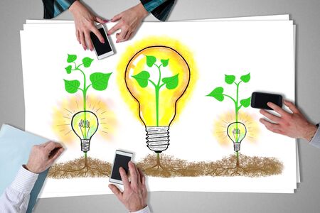 Ideas concept placed on a desk with hands using smartphonesの写真素材