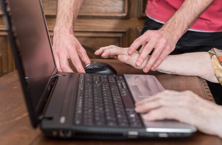 Old woman learning to use a laptop