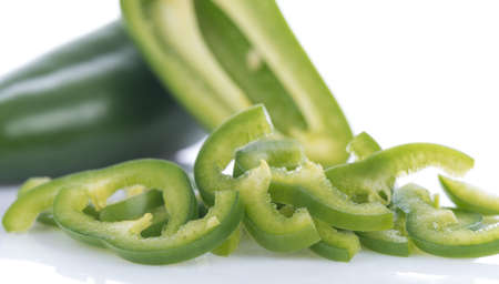 Mini green pepper cut in pieces, isolated on white