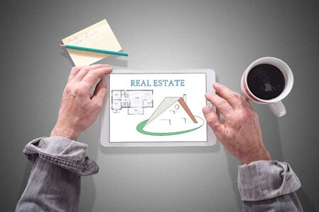 Male hands using a tablet showing real estate concept