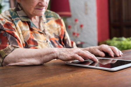 Old woman using tablet at homeの写真素材