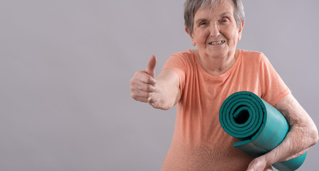 Happy old woman going for fitness with thumb upの写真素材