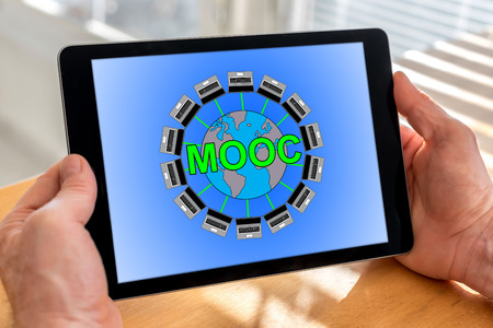 Male hands holding a tablet with mooc conceptの写真素材