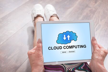 Woman sitting on the floor with a tablet showing cloud computing concept
