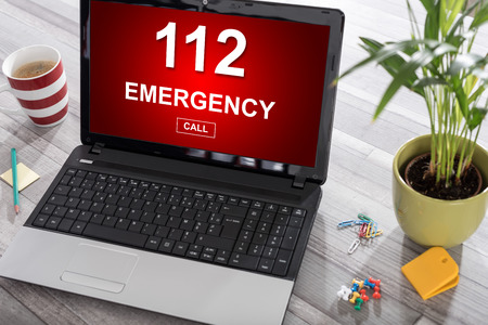 Laptop on a desk with emergency concept on the screenの写真素材