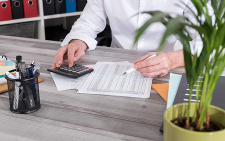 Businessman doing his accounting with calculatorの写真素材