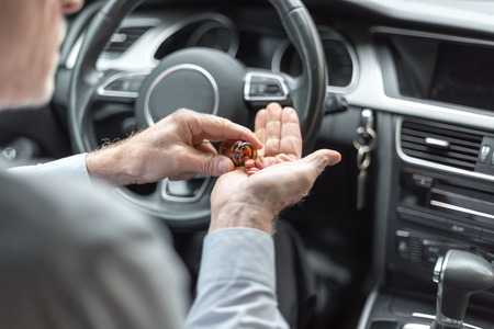 Man taking drugs before driving his carの写真素材