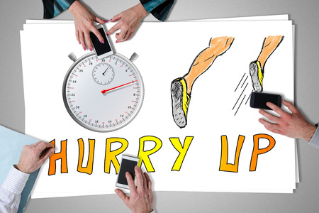 Deadline concept placed on a desk with hands using smartphonesの写真素材