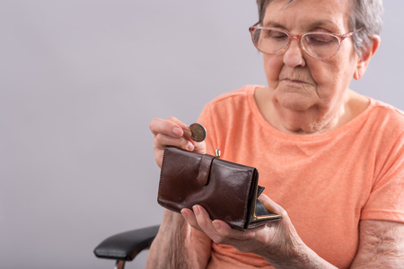 Elderly woman sitting and counting her moneyの写真素材