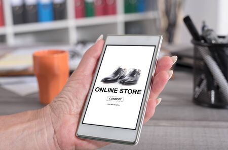 Female hand holding a smartphone with online store conceptの写真素材