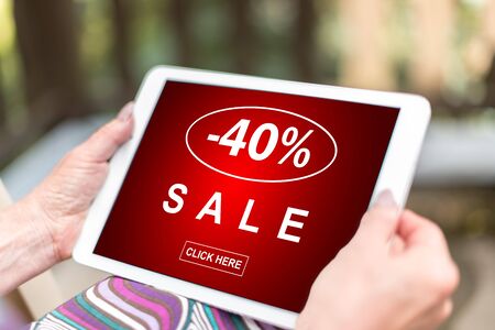 Female hands holding a tablet with sale conceptの写真素材