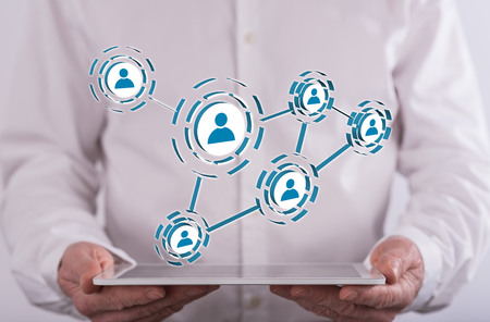 Social media and teamwork concept above a tablet held by a man in background