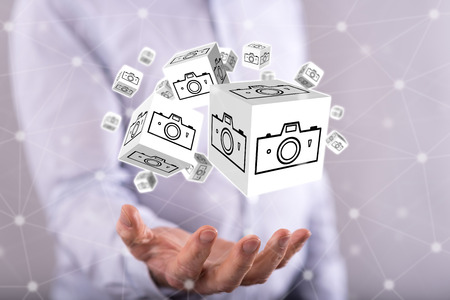 Pictures sharing concept above the hand of a man in backgroundの写真素材