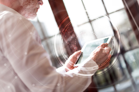 Senior businessman using tablet, light effect, double exposure with networkの写真素材