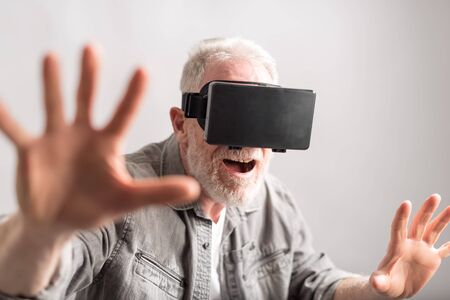 Senior man using a virtual reality headsetの写真素材