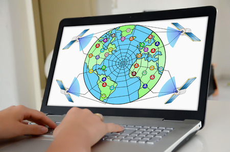 Hands on a laptop with screen showing global web network conceptの写真素材
