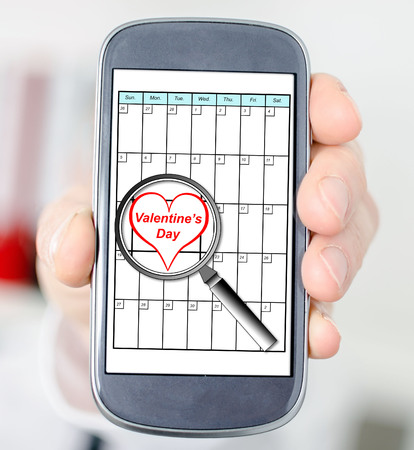 Valentines day on planner enlarged by a magnifying glassの写真素材