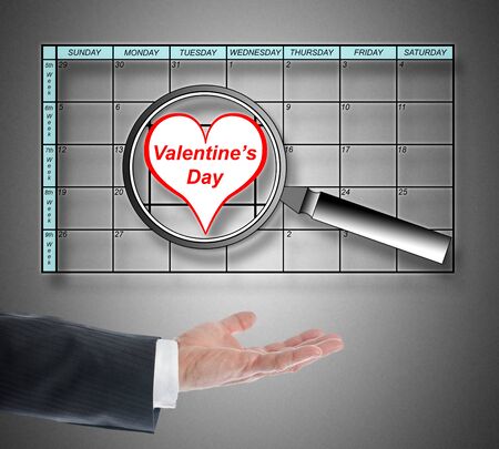 Valentines day on planner enlarged by a magnifying glassの写真素材