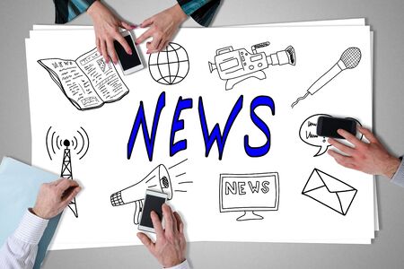 News concept placed on a desk with hands using smartphonesの写真素材