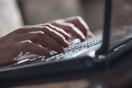 Hands typing on a laptop, hard light effectの写真素材