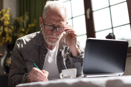 Senior businessman working at home, hard light effectの写真素材