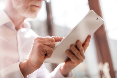 Senior businessman using tablet, flare and light effectsの写真素材