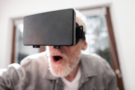 Senior man using a virtual reality headset, closeupの写真素材