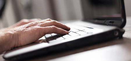 Hands typing on a laptop