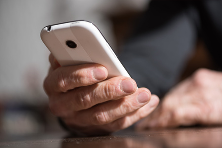 Hand holding a phone, closeup, hard light effect