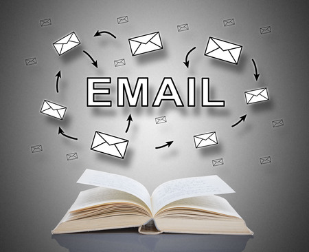 Email concept above an open bookの写真素材