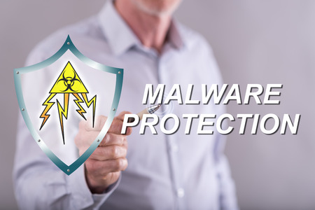 Man touching a malware protection concept on a touch screen with his fingerの写真素材