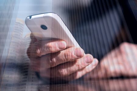 Hand holding a phone, closeup, double exposureの写真素材
