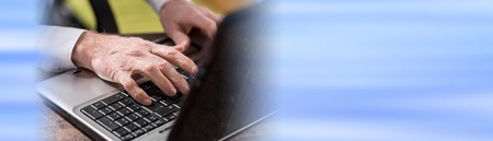 Male hands typing on laptop keyboardの写真素材