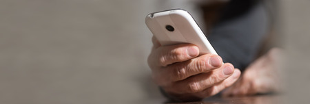 Male hand holding a mobile phoneの写真素材