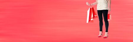 Woman carrying red shopping bagsの写真素材