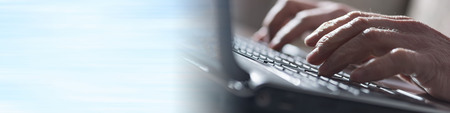 Male hands typing on laptop keyboardの写真素材