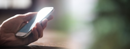 Male hand holding a mobile phoneの写真素材