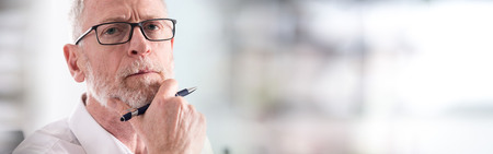 Portrait of thoughtful senior businessman with glassesの写真素材