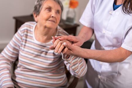 Nurse holding the hand of an old womanの写真素材
