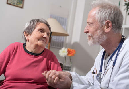 Doctor comforting an old patientの写真素材