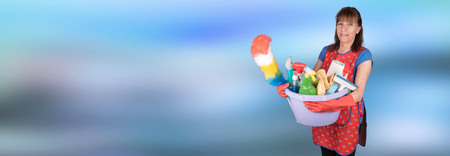 Smiling maid holding a bucket with cleaning equipmentの写真素材